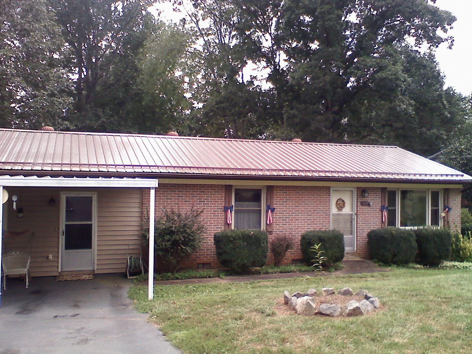 Bronze metal roof and carport on a brick ranch home — Roof Repair work by our crew in Lyle